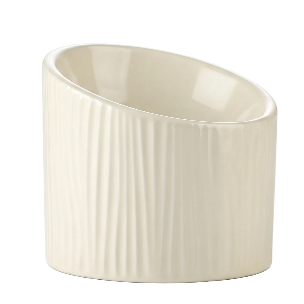 An off-white ceramic cup with a slanted oval shape and vertical fluted texture on the exterior, shown against a plain white background.
